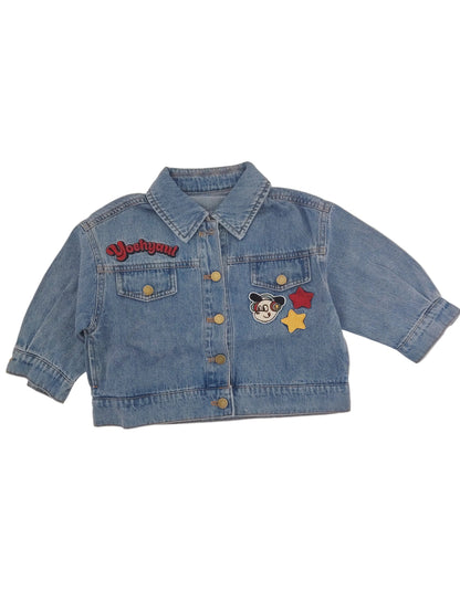 Blue denim jacket with patches on a light gray background